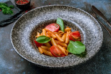 Mavi beton masada gri tabakta makarna Penne arabiata