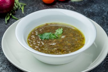 Beyaz tabakta yeşil mercimek çorbası