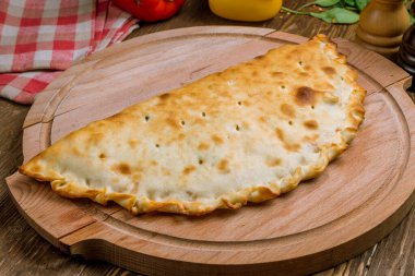 Tahtada kapalı calzone pizza. 