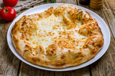 Tahta masadaki peynirli khachapuri.