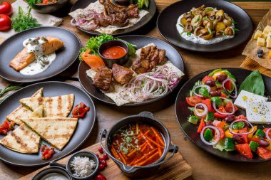 Masada çeşitli yiyecekler var. Domuz kebabı, somon ızgarası, borş, Yunan salatası, labrador rafı, mantarlı kızarmış patates..