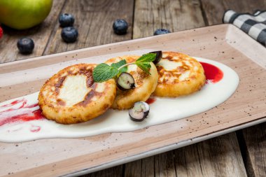 Ahşap arka planda süzme peynirden peynirli kekler.