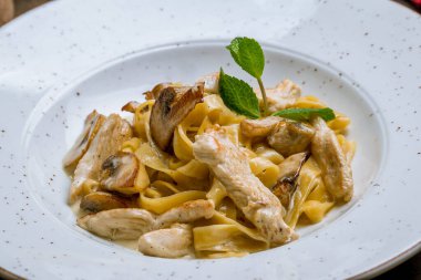 Köy arka planında tavuk ve mantarlı makarna.