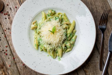 Pesto soslu makarna ve eski ahşap masada karides.