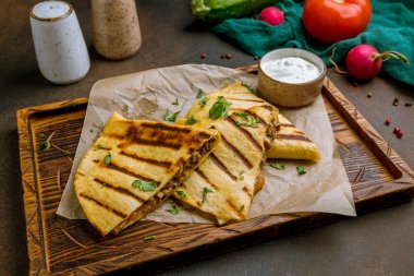 Köy arka planında sığır eti ve soslu Quesadilla.