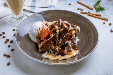 Böğürtlenli Belçika waffle 'ı, dondurma ve gri arka planda kahve.