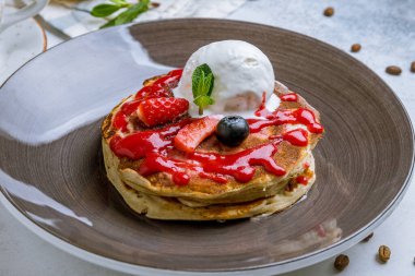 Böğürtlenli krep ve gri arka planda dondurma.