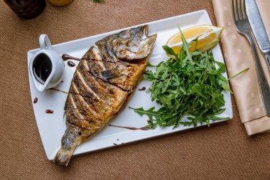 Dorado beyaz tabakta ızgara yapıyor.