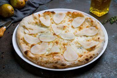 Armutlu pizza ve koyu beton arka planda Gorgonzola peyniri.