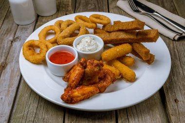 Ahşap masa arkasında çeşitli bira atıştırmalıkları.