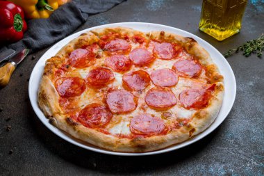 Koyu beton arka planda biberli pizza.