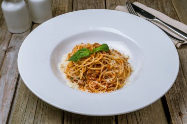 Ahşap masa arkasında makarna bolonez.