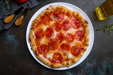 Koyu beton arka planda biberli pizza.