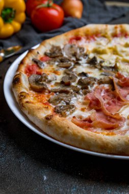 Koyu beton arka planda dört sezon pizza.