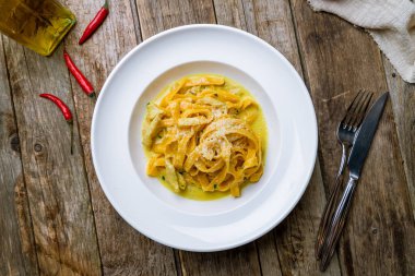 Tavuklu makarna ve ahşap masada sosis.