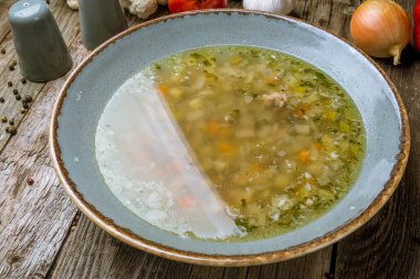 Ahşap arka planda turkuaz kasede sebze çorbası çorbası çorbası.