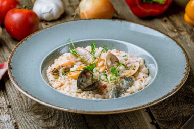 Lezzetli risotto, deniz ürünleri ve ahşap masada pilav.