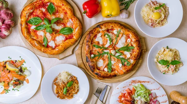 Pizza, makarna ve salatalı İtalyan yemeği seti. 