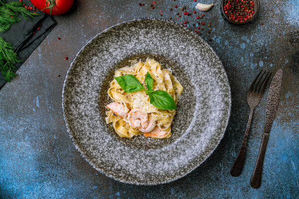 Fettuccine with shrimp and salmon on grey plate