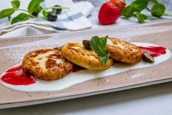 Gri arka planda süzme peynirden peynirli kekler.