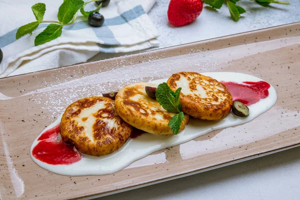 Gri arka planda süzme peynirden peynirli kekler.