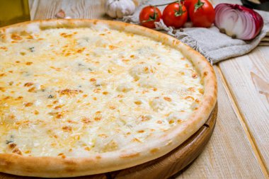 Tahta arka planda lezzetli Pizza Quattro formaggi.