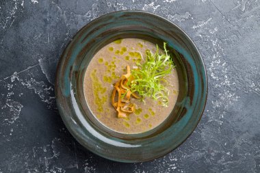 Kremalı porcini mantar çorbası. Koyu taş masa manzaralı.