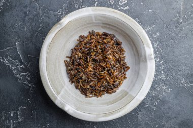 Gri tabakta kaynamış siyah pirinç. Koyu taş masa manzaralı.