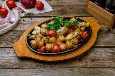 Tavuklu kızarmış tavuk ve patates eski ahşap masada.