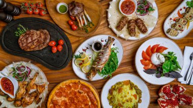 Sulu Ribeye bifteği, kızarmış deniz levreği, kuzu pirzolası, dana kebabı, patates rulosu, buratta ve domatesli salata, tavuk tütünü, pizza pepperonisi, pilav ve garnet üstü yemek.