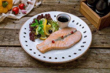 Eski ahşap masanın üstünde somon bifteği.