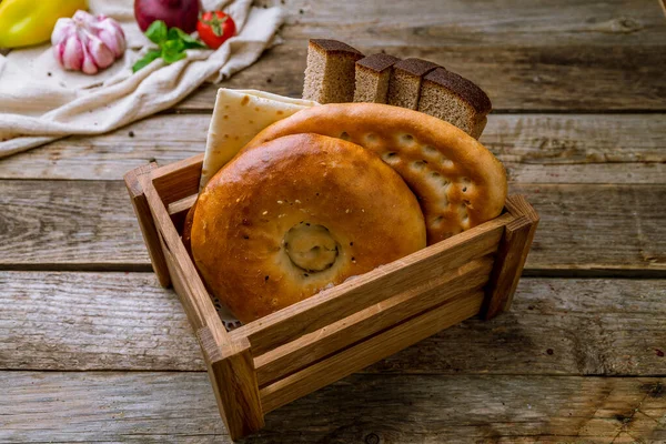 古い木製のテーブルの上に異なるパンとパンバスケット — ストック写真