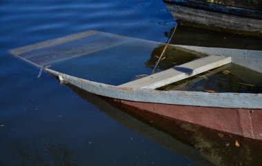 Terk edilmiş kayık su dolu ve göl kıyısında batmış.