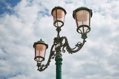 Bulutlu gökyüzüne karşı tipik 3 başlı fenerler, Venedik, İtalya