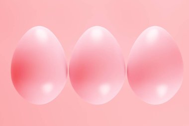 Pembe arka planda üç parlak yumurta, mesaj ve parlak stüdyo ışıkları için yer var. 3d oluşturma