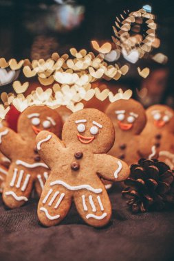 Noel ağacının yanındaki ormanda yeni yılı kutlayan zencefilli kurabiye şeklinde birçok Noel kurabiyesi.