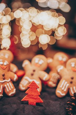 Noel ağacının yanındaki ormanda yeni yılı kutlayan zencefilli kurabiye şeklinde birçok Noel kurabiyesi.