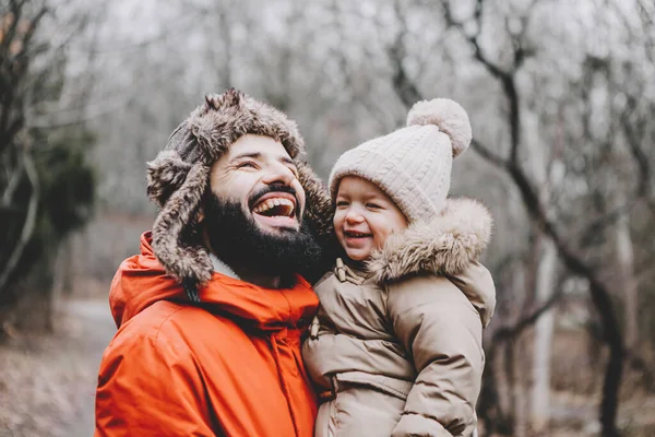 Handsome young dad and his little sweet daughter have fun outdoors in winter. Happy family spending time together. Family concept.