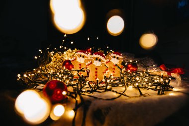 Koronavirüs salgınında yeni yıl ve Noel kutlaması, odaklanmamış ışıklarla kavramsal arka plan ve yüz maskeli kızıl adam, boşluğu kopyala