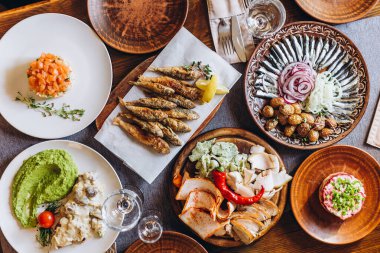 Slav usulü çeşitli lezzetli yemeklerle kaplı ev ahşap masa: ekşi ekmek hamuru, tuzlu ve kızarmış balık, patates, kızarmış et ve salata