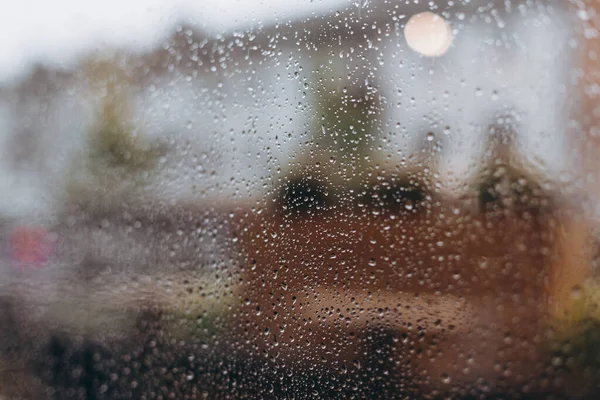 raindrops on a panoramic window, view from the middle of a coffee shop on a city street during a downpour. selective focus, copy space