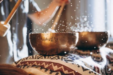 Bir adam şarkı kasesi tutuyor ve Tibet kasesi çalıyor.