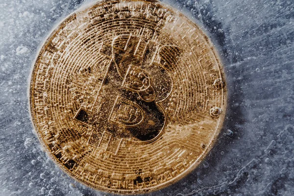 Golden symbol bitcoin frozen and covered with ice. Concept of Cryptocurrency crisis and the fall of the cost of bitcoin