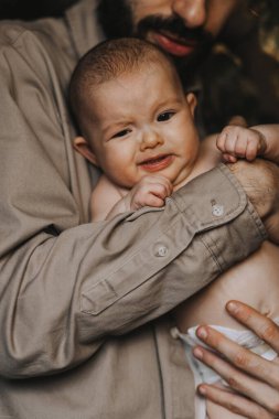 Yeni doğmuş bebeği omuzlarında taşıyan beyaz sakallı bir baba. Erkek, anne ve babası kucağında bir oğul taşıyor. Otantik yaşam tarzı belgesel anı. Bekar baba aile hayatı konsepti