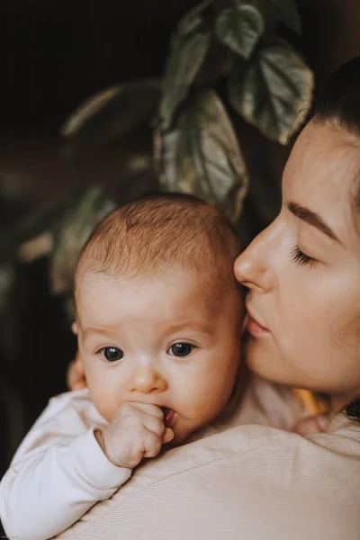 Młoda Brunetka Mama Jej Nowonarodzone Dziecko Ramionach Domowe Zdjęcie Ciemnym — Zdjęcie stockowe