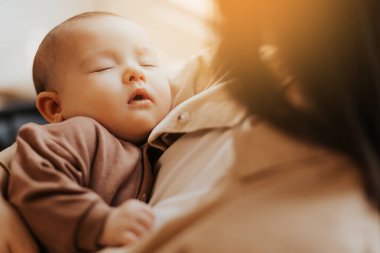 Annesinin kollarında mutlu bir bebeğin portresi