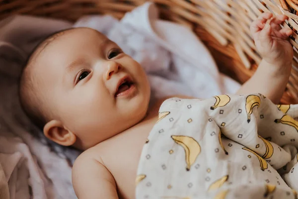 ベビーベッドの中に寝そべってカメラを見てきれいな柔らかい肌かわいい顔ベッドルームの新生児の幸せそうな顔 子供のテーマのための美しい背景 — ストック写真