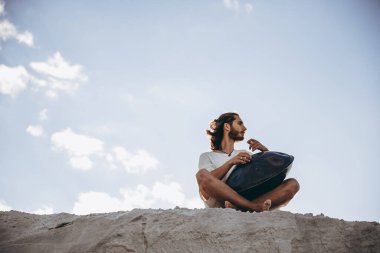 Sıcak çölün ortasında oturan bir müzisyen. İnsansız büyük bir alan. Genç bir hipster için favori hobi.