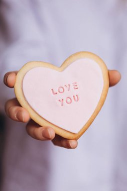 Kalp şeklinde kurabiyeler pembe şekerli ve üzerinde 