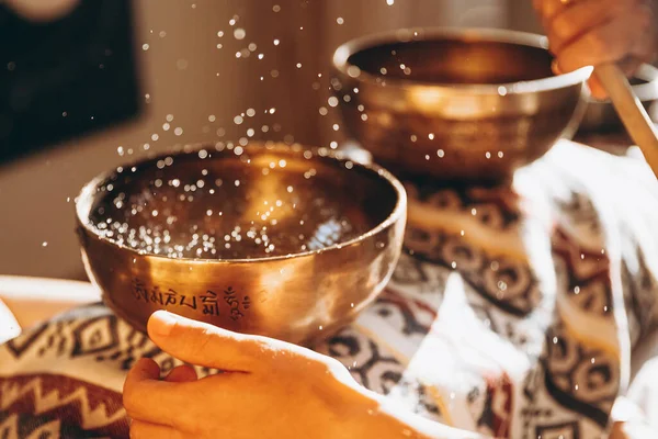 Spa salonunda Nepal Buda bakır kasesi. Genç sakallı adam masaj terapisi yapıyor. Spa 'da şarkı söylüyor. Ses terapisi, dinlenme, meditasyon, sağlıklı konsept.